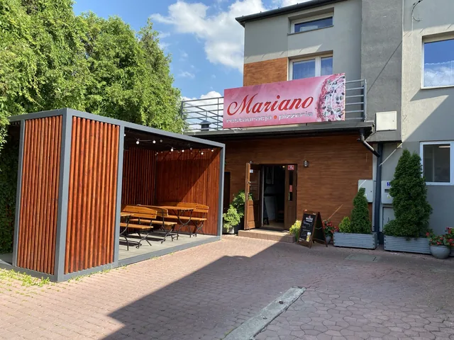 Wejście do restauracji Mariano z drewnianą wiatą i miejscami do siedzenia