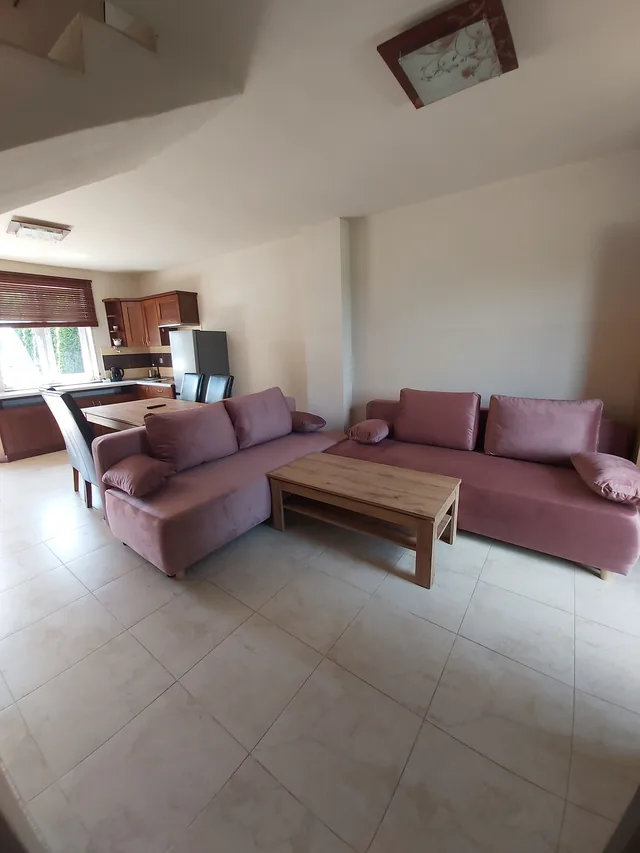 Salon w apartamencie z różowymi kanapami i drewnianym stolikiem