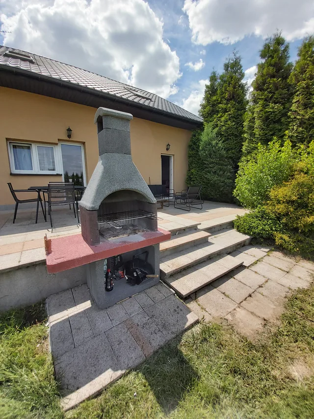 Ogród przy obiekcie z murowanym grillem i miejscem do wypoczynku